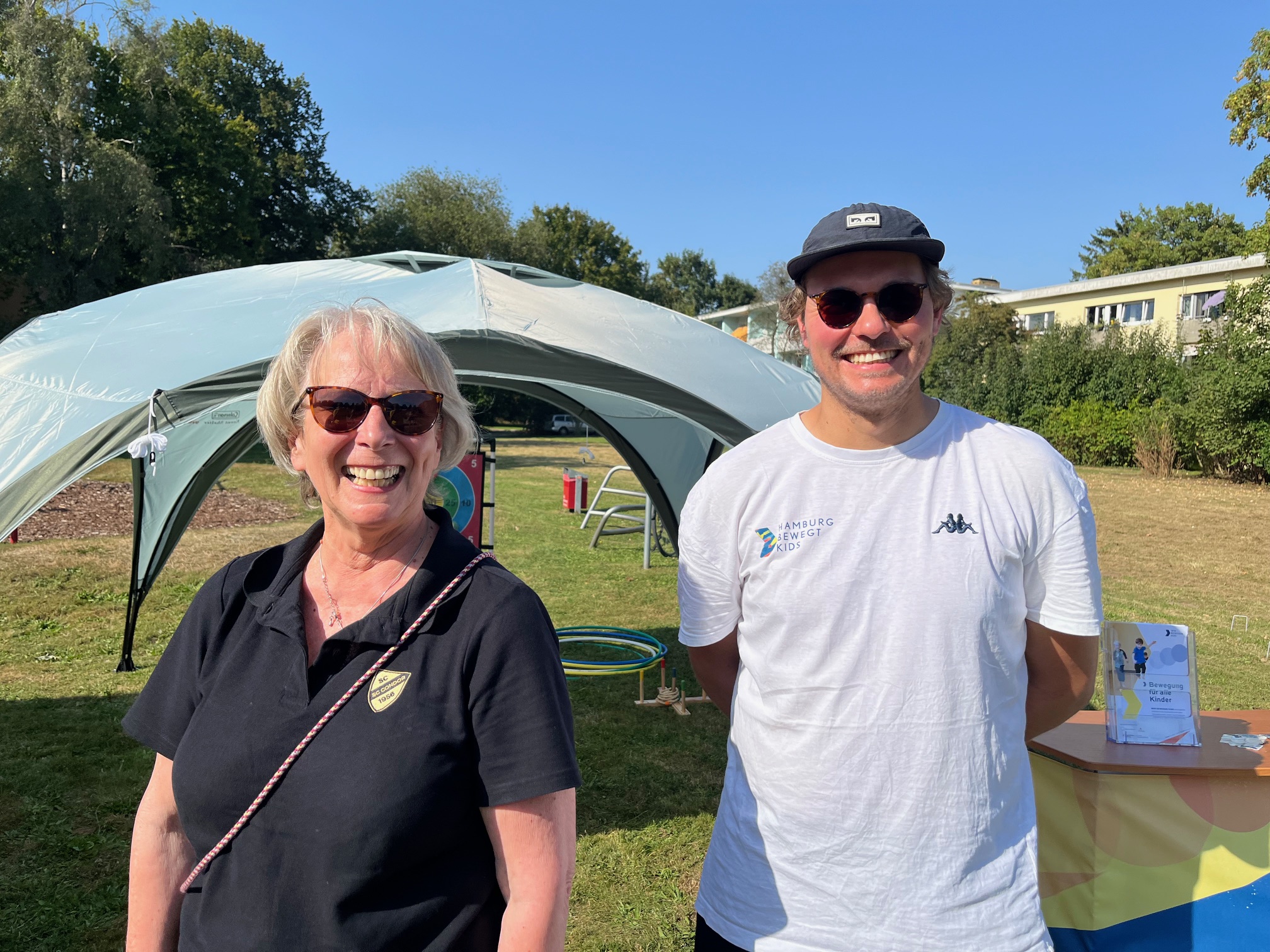 District Manager und Kids Coach Malte von „Hamburg bewegt Kids“ mit Vertreterin des SC Condor von 1956 e. V. am Stand des Stadtteilfest Farmsen.