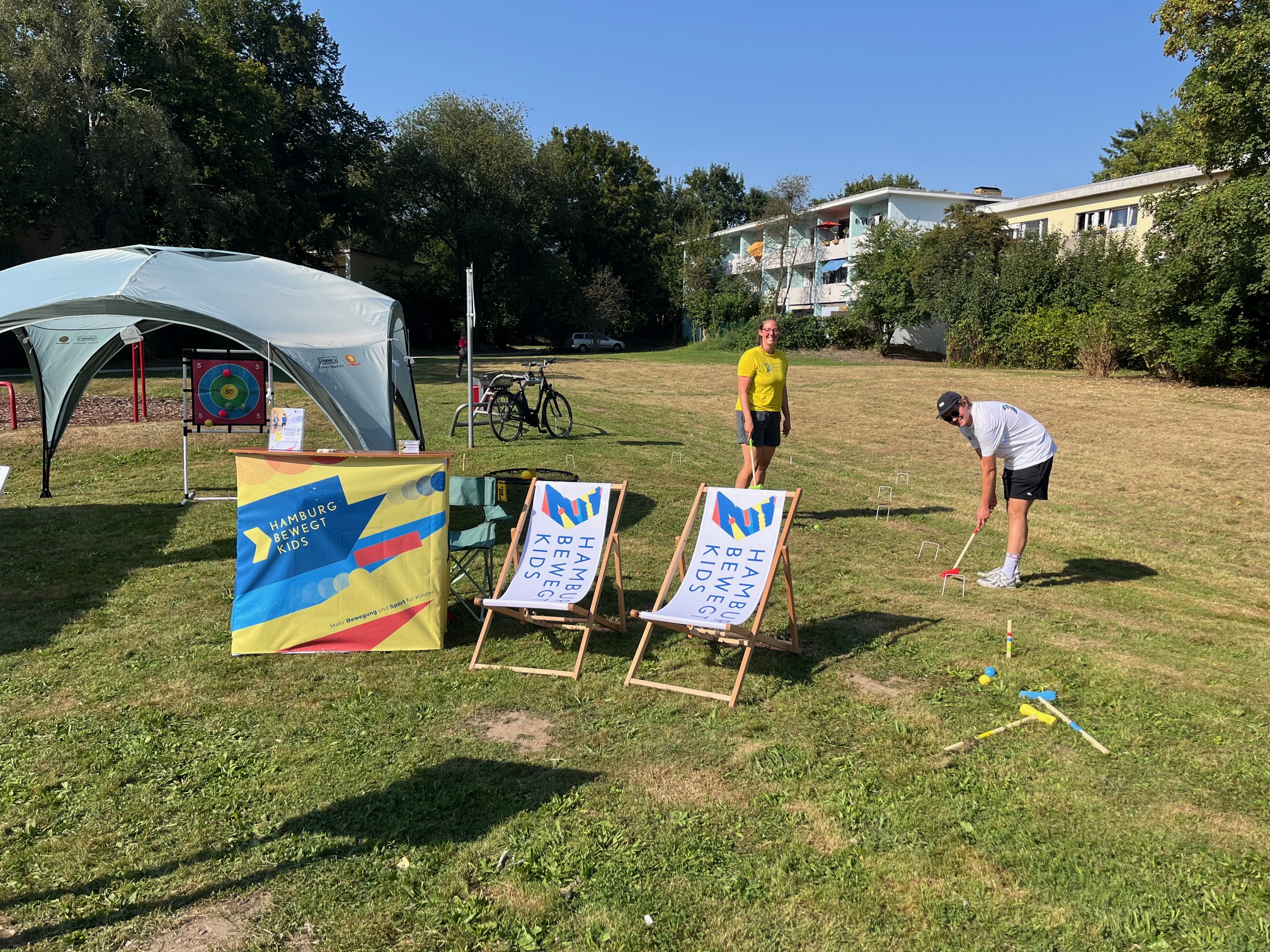 Lachende Lina und Malte von „Hamburg bewegt Kids“ zeigen das Sport- und Bewegungsangebot für Kinder am Stand beim Stadtteilfest in Farmen